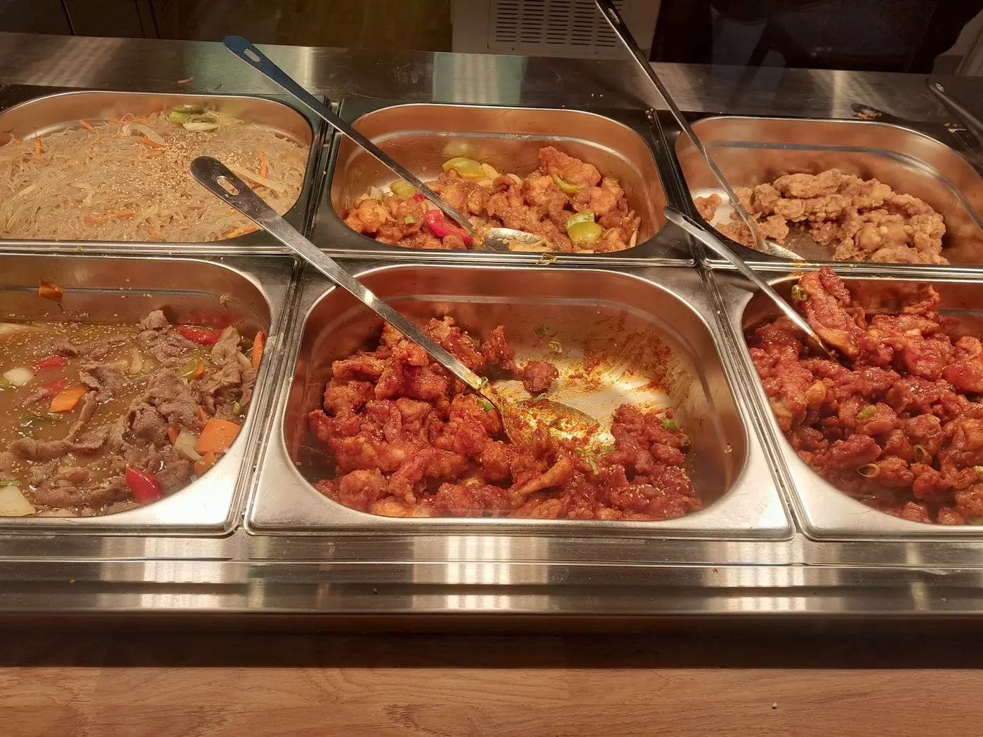 The serve-over counter, trays of chicken, noodles and rice under the heat